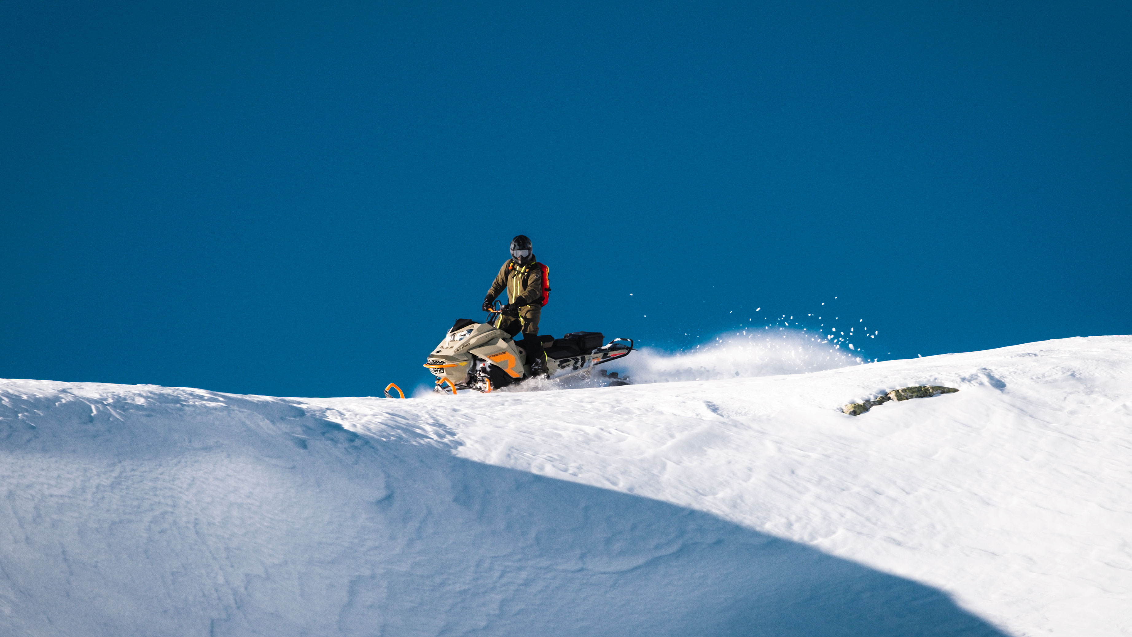 Man on top of a hill on his Ski-Doo Freeride